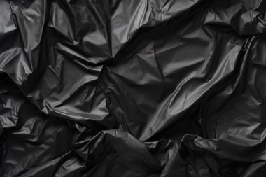 Siyah selofan çöp torbası dokusunun işlenmiş kolajı. Pankart, arkaplan veya 3B haritalama için doku