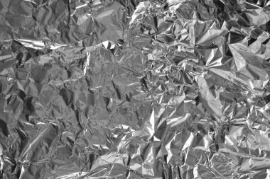 Parlak metalden işlenmiş gümüş folyo buruşmuş ambalaj malzemesi dokusu arka planı.