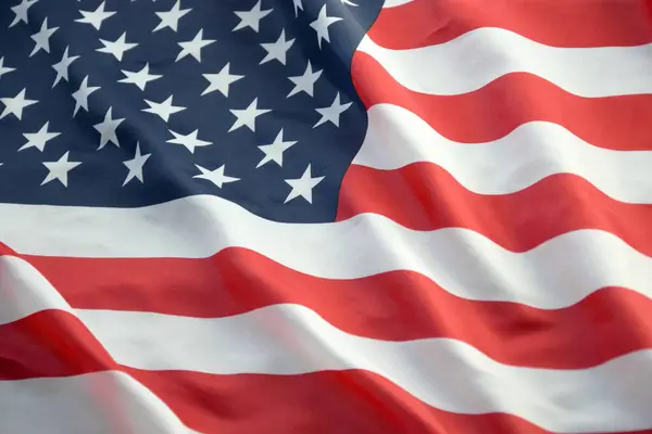 Amerika Birleşik Devletleri bayrağı, yıldız ve şeritlerle kaplıdır. Resmi Amerikan Bayrağı gün ışığında kıvrımlarla el sallıyor