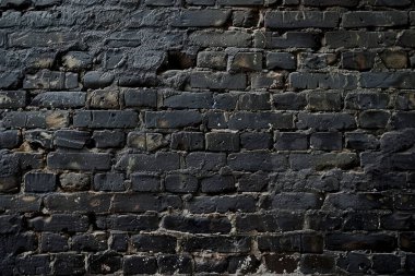 Eski getto siyah tuğla duvarının fotoğrafı. Arkaplan veya haritalama için arkaplan dokusu