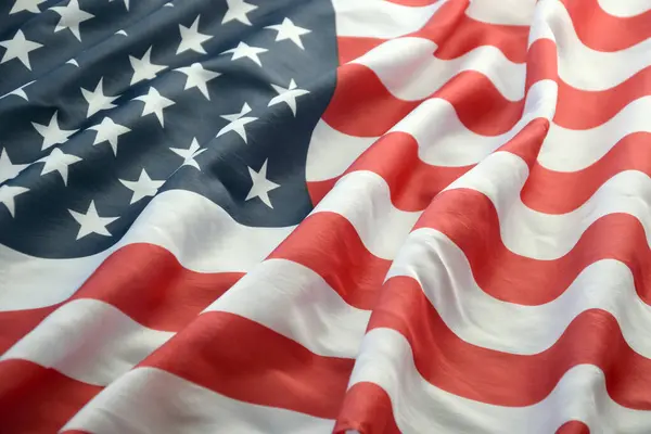 Amerika Birleşik Devletleri bayrağı, yıldız ve şeritlerle kaplıdır. Resmi Amerikan Bayrağı gün ışığında kıvrımlarla el sallıyor