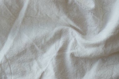 Arka plan olarak beyaz renkli gri tekstil peçetesi. Katlanmış dekoratif mutfak pamuğu havlusu kapat.