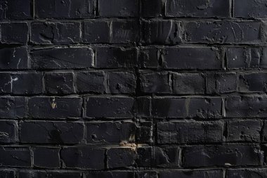 Eski tuğla duvarın resmi siyah renge boyanmış. Yakın plan. Arkaplan veya haritalama için arkaplan dokusu
