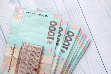Beyaz ahşap masa üzerinde modern tasarımı olan büyük miktarda Ukrayna yapımı 100 Hryvnia para faturası. Finansal konsept, iş ücretleri