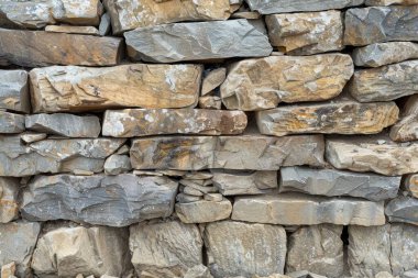 Eski gri ve kahverengi uzun taş duvarın fotoğrafı. Arkaplan veya haritalama için arkaplan dokusu