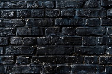 Eski tuğla duvarın resmi siyah renge boyanmış. Yakın plan. Arkaplan veya haritalama için arkaplan dokusu
