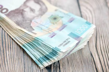 Ahşap arka planda modern tasarımı olan büyük miktarda Ukrayna yapımı 100 Hryvnia para faturası. Finansal konsept, iş ücretleri