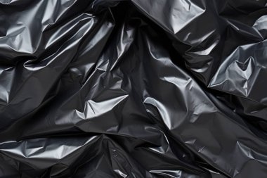Siyah selofan çöp torbası dokusunun işlenmiş kolajı. Pankart, arkaplan veya 3B haritalama için doku
