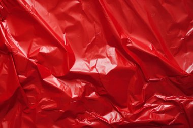 İşlenmiş kırmızı plastik selofan yüzey dokusu kolajı. Pankart, arkaplan veya 3B haritalama için doku
