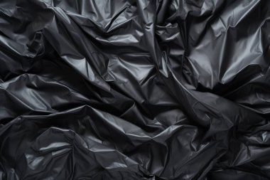 Siyah selofan çöp torbası dokusunun işlenmiş kolajı. Pankart, arkaplan veya 3B haritalama için doku