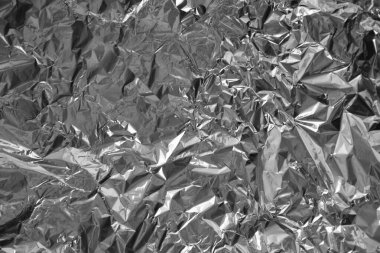 Parlak metalden işlenmiş gümüş folyo buruşmuş ambalaj malzemesi dokusu arka planı.