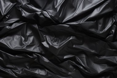 Siyah selofan çöp torbası dokusunun işlenmiş kolajı. Pankart, arkaplan veya 3B haritalama için doku