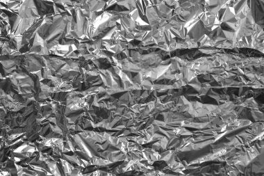 Parlak metalden işlenmiş gümüş folyo buruşmuş ambalaj malzemesi dokusu arka planı.