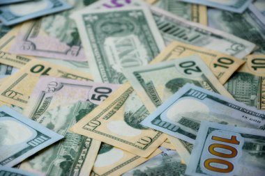 Masada farklı adaylıklarda büyük miktarlarda Amerikan doları var. Doğal ışık altında birçok dolarlık banknotlar.