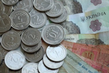 Ukraine money coins lying on mixed hryvnia banknotes, background. finance concept