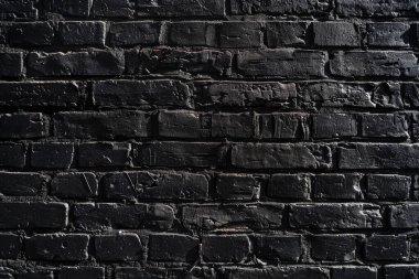 Eski tuğla duvarın resmi siyah renge boyanmış. Yakın plan. Arkaplan veya haritalama için arkaplan dokusu