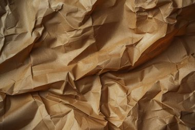 Buruşuk kahverengi kağıdın fotoğrafı. Kapatın. Arkaplan veya haritalama için arkaplan dokusu