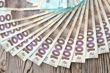 Ahşap arka planda modern tasarımı olan büyük miktarda Ukrayna yapımı 100 Hryvnia para faturası. Finansal konsept, iş ücretleri