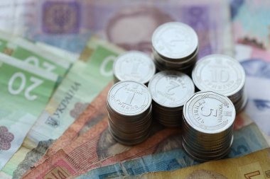 Birkaç yığın Ukrayna parası eski Hryvnia banknotlarının üzerinde yatıyor.