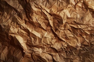 Buruşuk kahverengi kağıdın fotoğrafı. Kapatın. Arkaplan veya haritalama için arkaplan dokusu