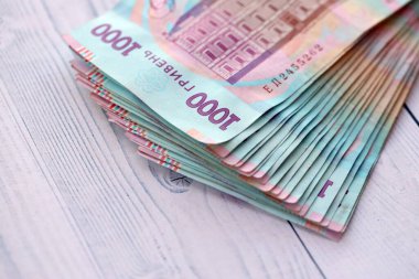 Beyaz ahşap masa üzerinde modern tasarımı olan büyük miktarda Ukrayna yapımı 100 Hryvnia para faturası. Finansal konsept, iş ücretleri