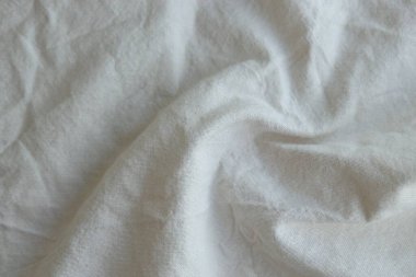 Arka plan olarak beyaz renkli gri tekstil peçetesi. Katlanmış dekoratif mutfak pamuğu havlusu kapat.