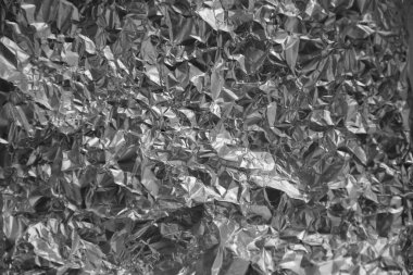 Parlak metalden işlenmiş gümüş folyo buruşmuş ambalaj malzemesi dokusu arka planı.