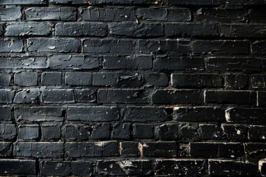 Eski tuğla duvarın resmi siyah renge boyanmış. Yakın plan. Arkaplan veya haritalama için arkaplan dokusu