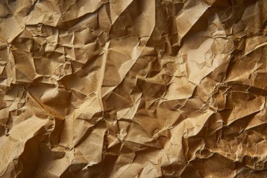 Buruşuk kahverengi kağıdın fotoğrafı. Kapatın. Arkaplan veya haritalama için arkaplan dokusu