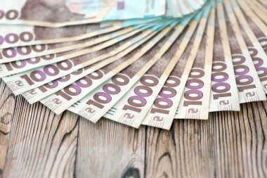 Ahşap arka planda modern tasarımı olan büyük miktarda Ukrayna yapımı 100 Hryvnia para faturası. Finansal konsept, iş ücretleri