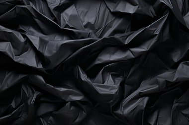 Siyah selofan çöp torbası dokusunun işlenmiş kolajı. Pankart, arkaplan veya 3B haritalama için doku