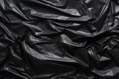 Siyah selofan çöp torbası dokusunun işlenmiş kolajı. Pankart, arkaplan veya 3B haritalama için doku
