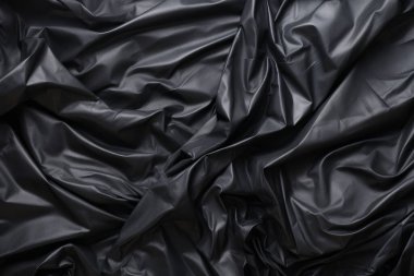 Siyah selofan çöp torbası dokusunun işlenmiş kolajı. Pankart, arkaplan veya 3B haritalama için doku