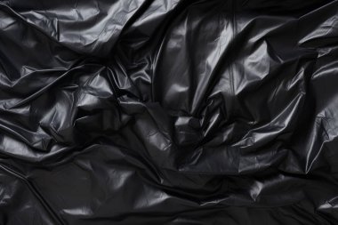 Siyah selofan çöp torbası dokusunun işlenmiş kolajı. Pankart, arkaplan veya 3B haritalama için doku