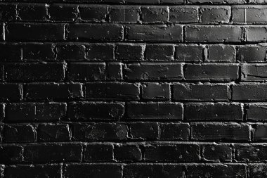 Eski tuğla duvarın resmi siyah renge boyanmış. Yakın plan. Arkaplan veya haritalama için arkaplan dokusu
