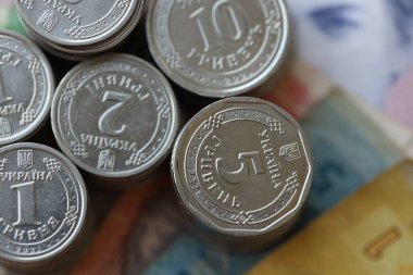 Birkaç yığın Ukrayna parası eski Hryvnia banknotlarının üzerinde yatıyor.