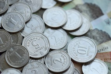 Ukraine money coins lying on mixed hryvnia banknotes, background. finance concept