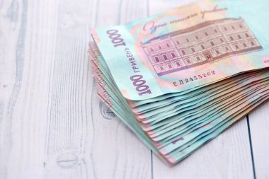 Beyaz ahşap masa üzerinde modern tasarımı olan büyük miktarda Ukrayna yapımı 100 Hryvnia para faturası. Finansal konsept, iş ücretleri
