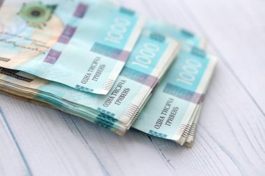 Beyaz ahşap masa üzerinde modern tasarımı olan büyük miktarda Ukrayna yapımı 100 Hryvnia para faturası. Finansal konsept, iş ücretleri