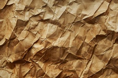 Buruşuk kahverengi kağıdın fotoğrafı. Kapatın. Arkaplan veya haritalama için arkaplan dokusu