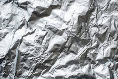 Gümüş krom renkli buruşuk alüminyum folyonun fotoğrafı. Arkaplan veya haritalama için arkaplan dokusu