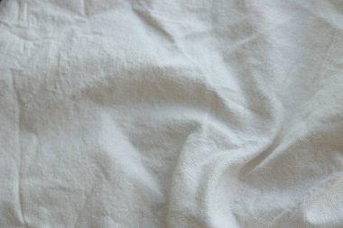 Arka plan olarak beyaz renkli gri tekstil peçetesi. Katlanmış dekoratif mutfak pamuğu havlusu kapat.