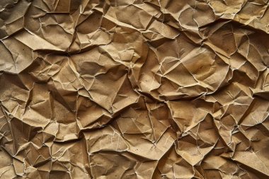 Buruşuk kahverengi kağıdın fotoğrafı. Kapatın. Arkaplan veya haritalama için arkaplan dokusu