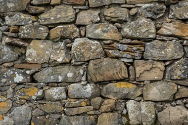 Eski gri ve kahverengi taş duvarın fotoğrafı. Arkaplan veya haritalama için arkaplan dokusu