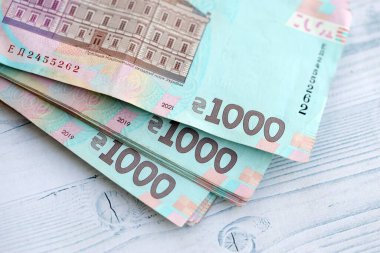 Beyaz ahşap masa üzerinde modern tasarımı olan büyük miktarda Ukrayna yapımı 100 Hryvnia para faturası. Finansal konsept, iş ücretleri
