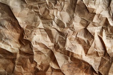 Buruşuk kahverengi kağıdın fotoğrafı. Kapatın. Arkaplan veya haritalama için arkaplan dokusu