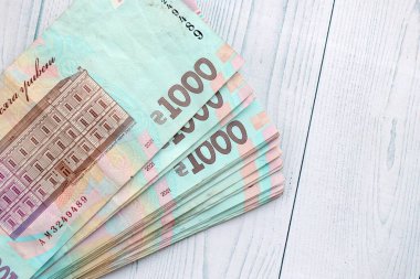 Beyaz ahşap masa üzerinde modern tasarımı olan büyük miktarda Ukrayna yapımı 100 Hryvnia para faturası. Finansal konsept, iş ücretleri