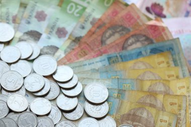 Ukraine money coins lying on mixed hryvnia banknotes, background. finance concept