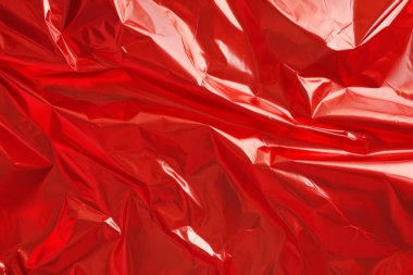İşlenmiş kırmızı plastik selofan yüzey dokusu kolajı. Pankart, arkaplan veya 3B haritalama için doku