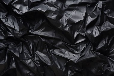 Siyah selofan çöp torbası dokusunun işlenmiş kolajı. Pankart, arkaplan veya 3B haritalama için doku